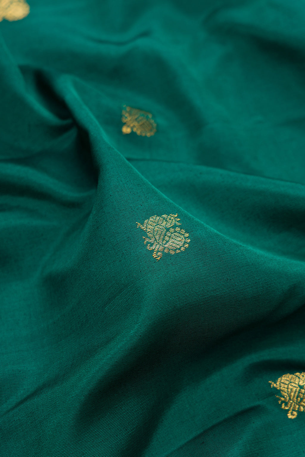 Close up of Green Gadwal Silk Saree with Zari Butta on the body and Temple Border.  displaying folds
