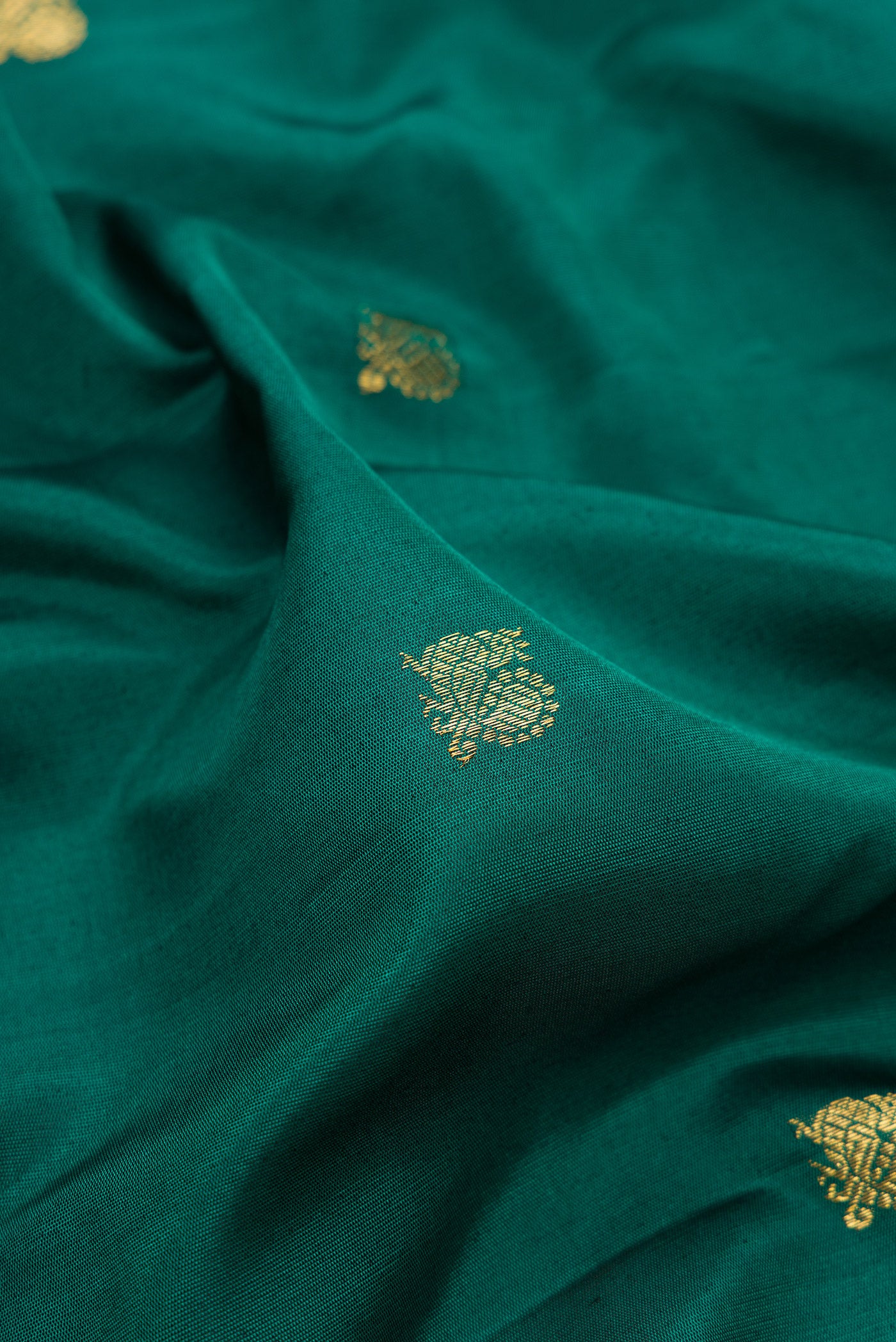 Close up of Green Gadwal Silk Saree with Zari Butta on the body and Temple Border.  displaying folds