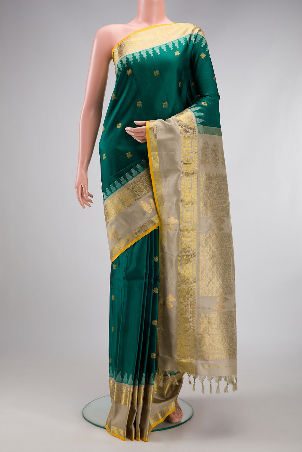 Green Gadwal Silk Saree with Zari Butta on the body and Temple Border.  displayed on a mannequin