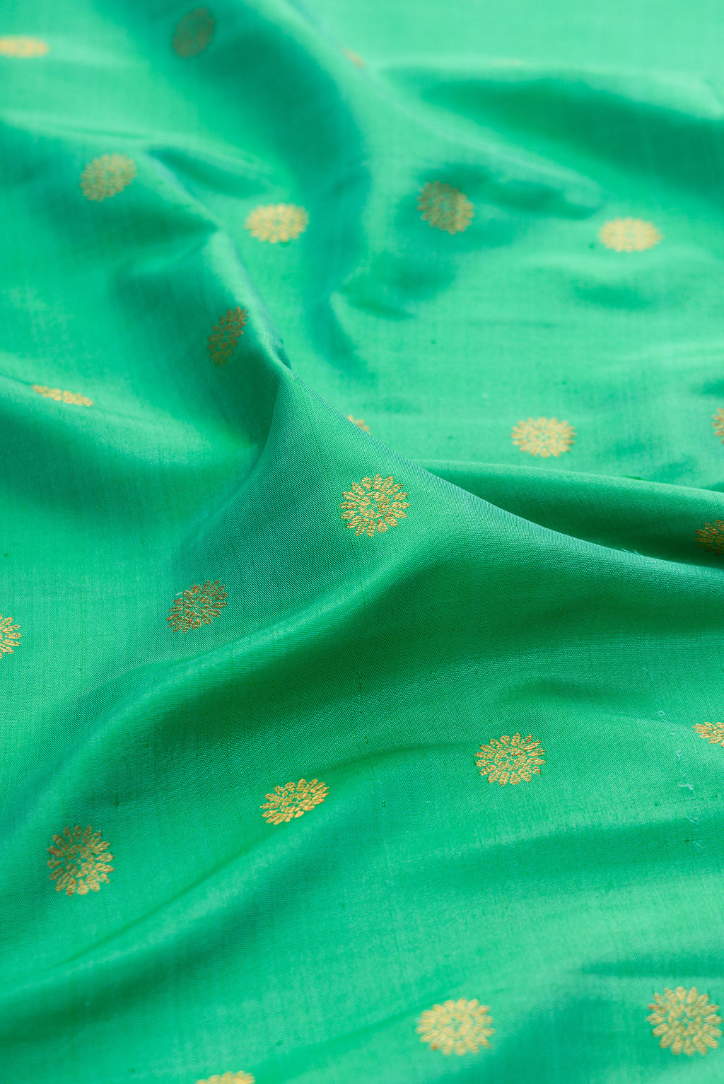 Close up of Sea Green Paithani Silk Saree with Zari Butta on the body and Paithani Border.  displaying folds