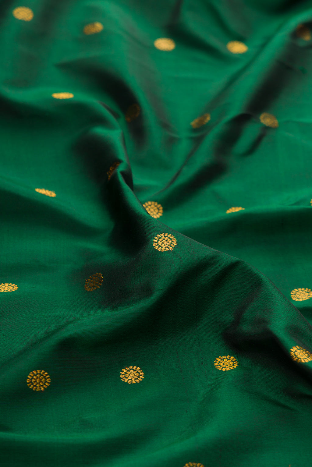 Close up of Bottle Green Paithani Silk Saree with Zari Butta on the body and Paithani Border.  displaying folds