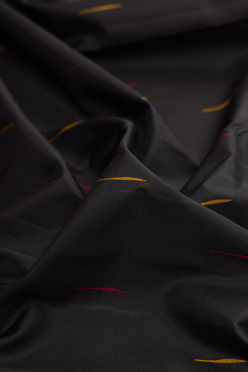 Close up of Black Kanchipuram Silk Saree with Thread Butta on the body and Temple Border.  displaying folds
