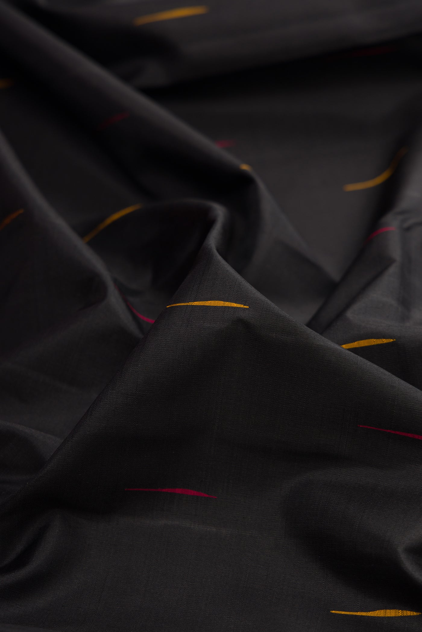 Close up of Black Kanchipuram Silk Saree with Thread Butta on the body and Temple Border.  displaying folds