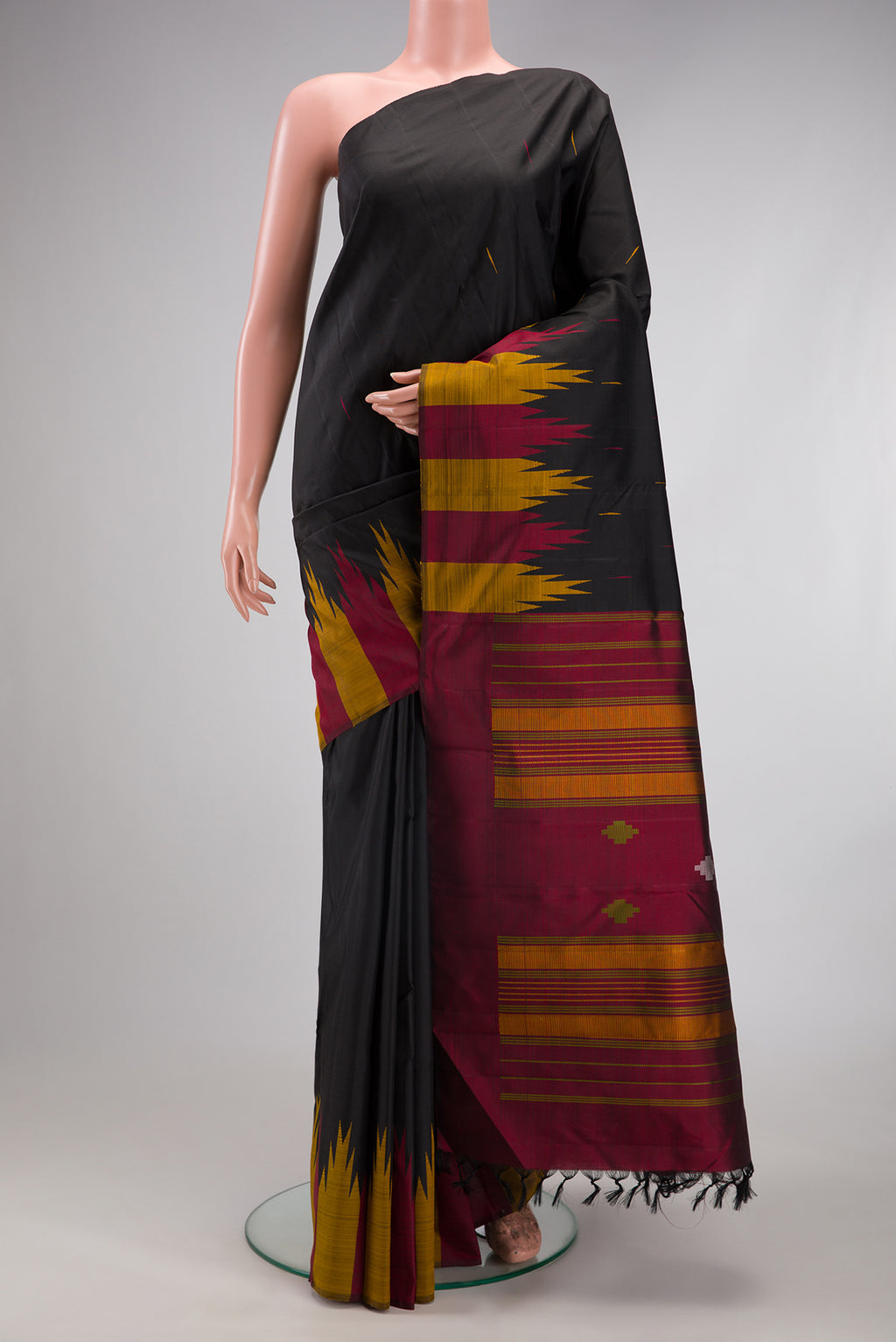 Black Kanchipuram Silk Saree with Thread Butta on the body and Temple Border.  displayed on a mannequin