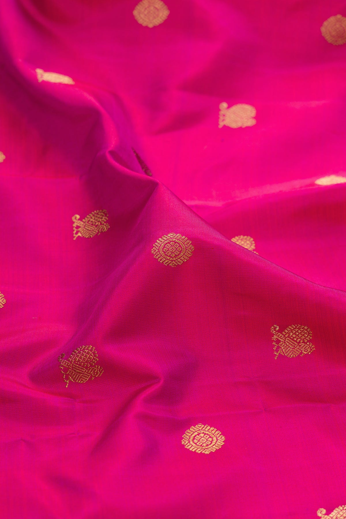 Close up of Pure Silk Pure Zari Magenta Kanjivaram Saree with Zari Butta on the body and Zari Border.  displaying folds