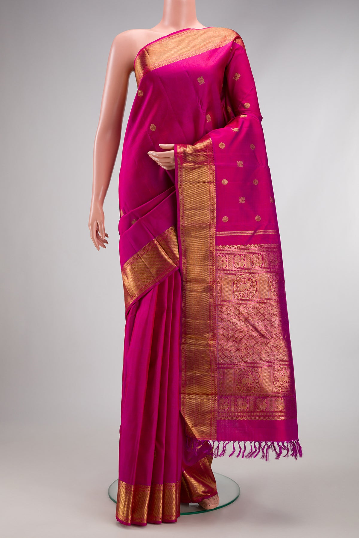 Pure Silk Pure Zari Magenta Kanjivaram Saree with Zari Butta on the body and Zari Border.  displayed on a mannequin