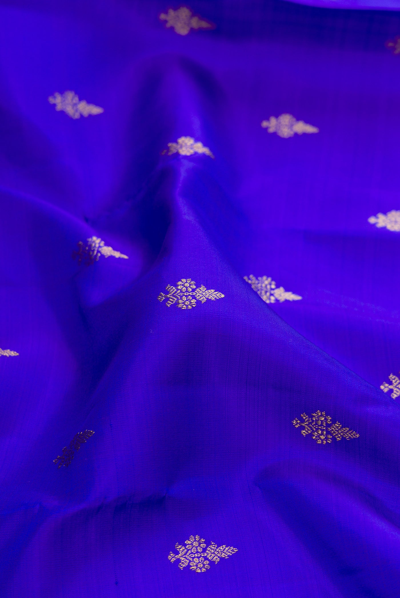Close up of Pure Silk Pure Zari Royal Blue Dual Tone Kanjivaram Saree with Zari Butta on the body and Zari Border.  displaying folds