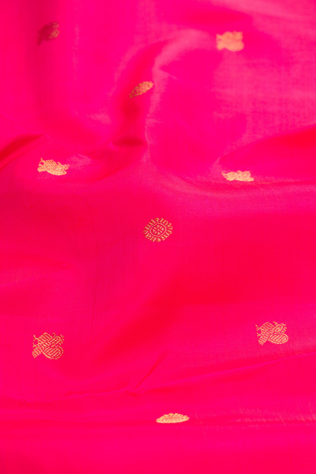 Close up of Pure Silk Pure Zari Pink Kanchipuram Saree with Zari Butta on the body and Zari Border.  displaying folds