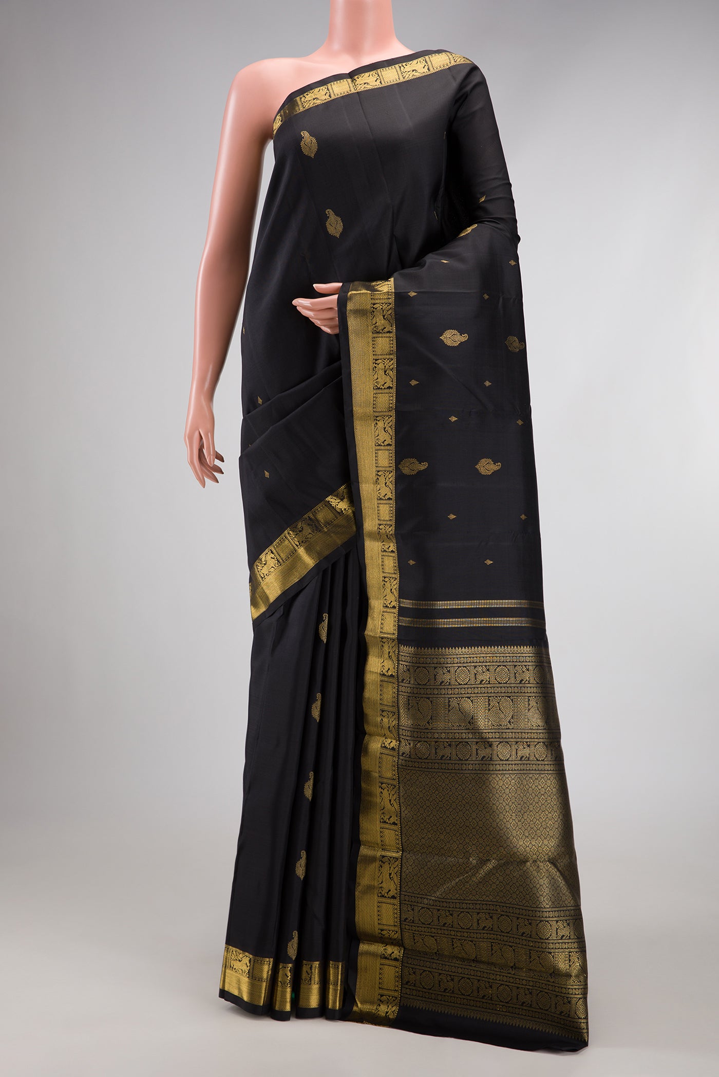 Black Kanchipuram Silk Saree with Zari Butta on the body and Zari Border.  displayed on a mannequin
