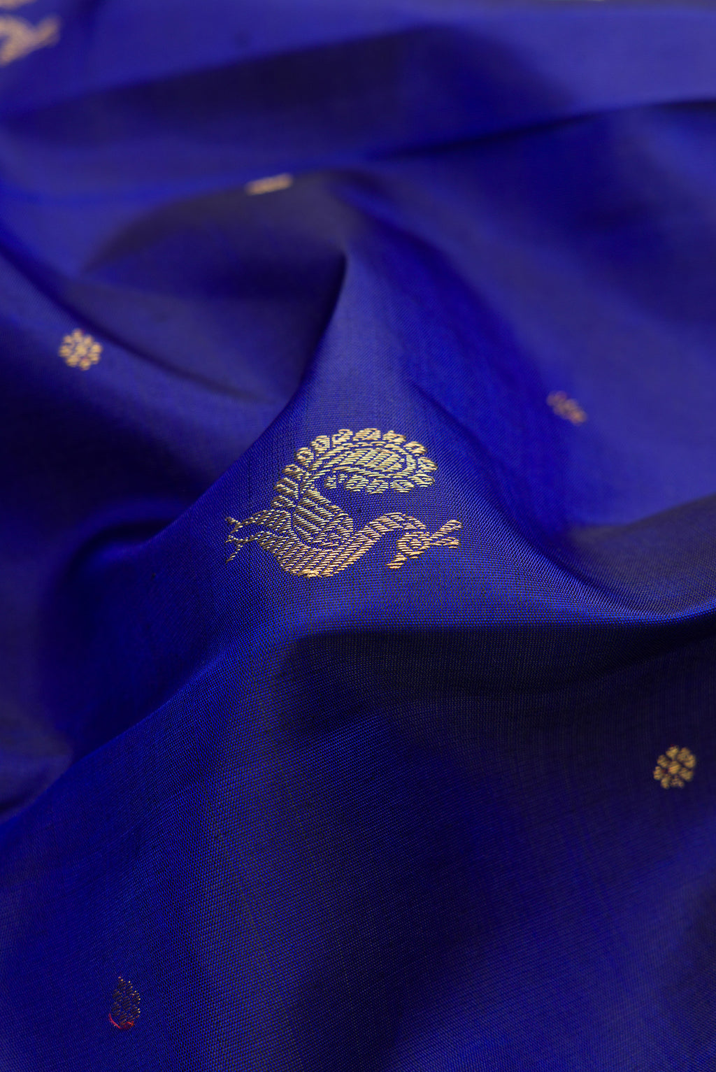 Close up of Pure Silk Pure Zari Royal Blue Kanchipuram Saree with Zari Butta on the body and Without Border.  displaying folds
