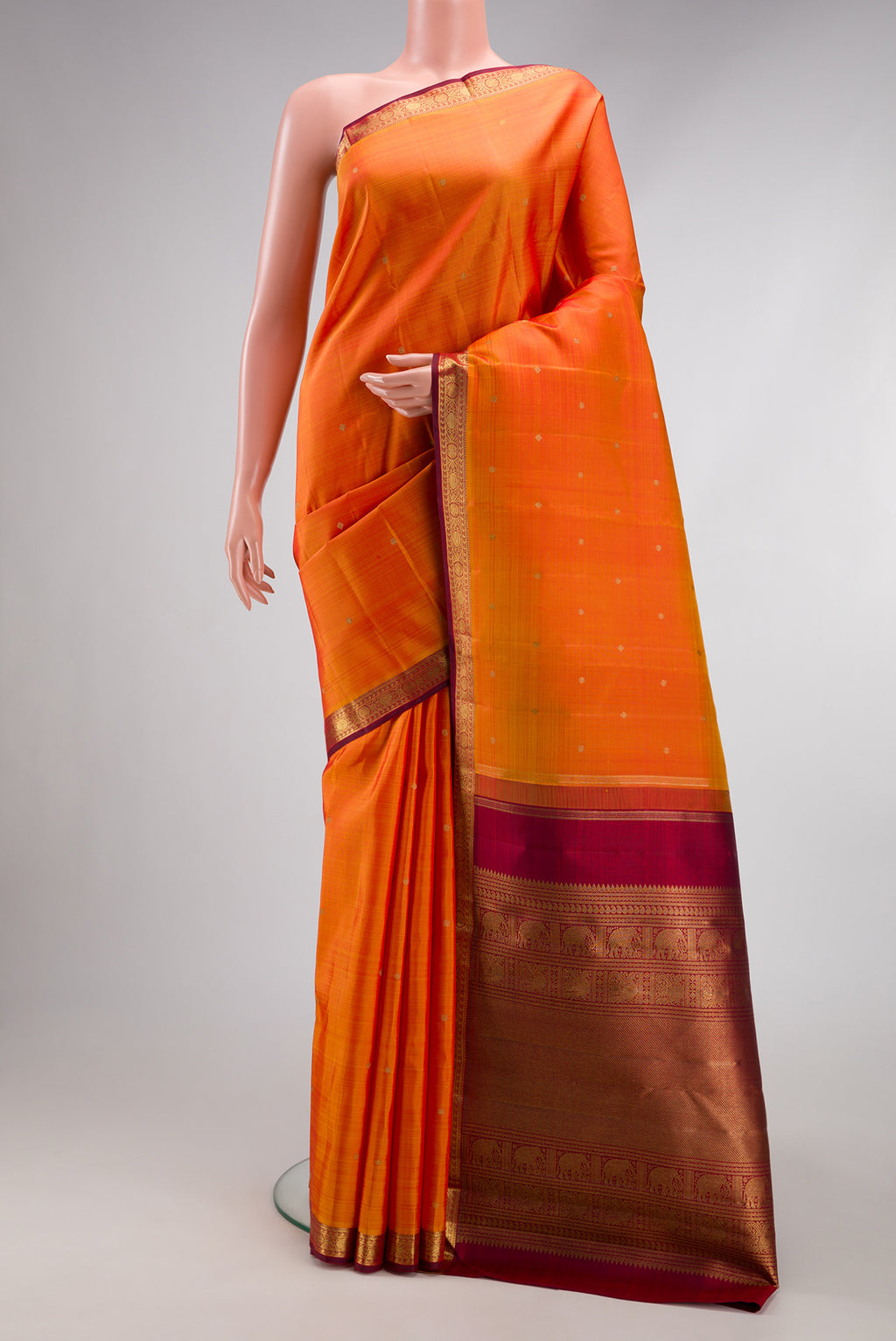 Orange Dual Tone Kanchipuram Silk Saree with Zari Butta on the body and Zari Border.  displayed on a mannequin