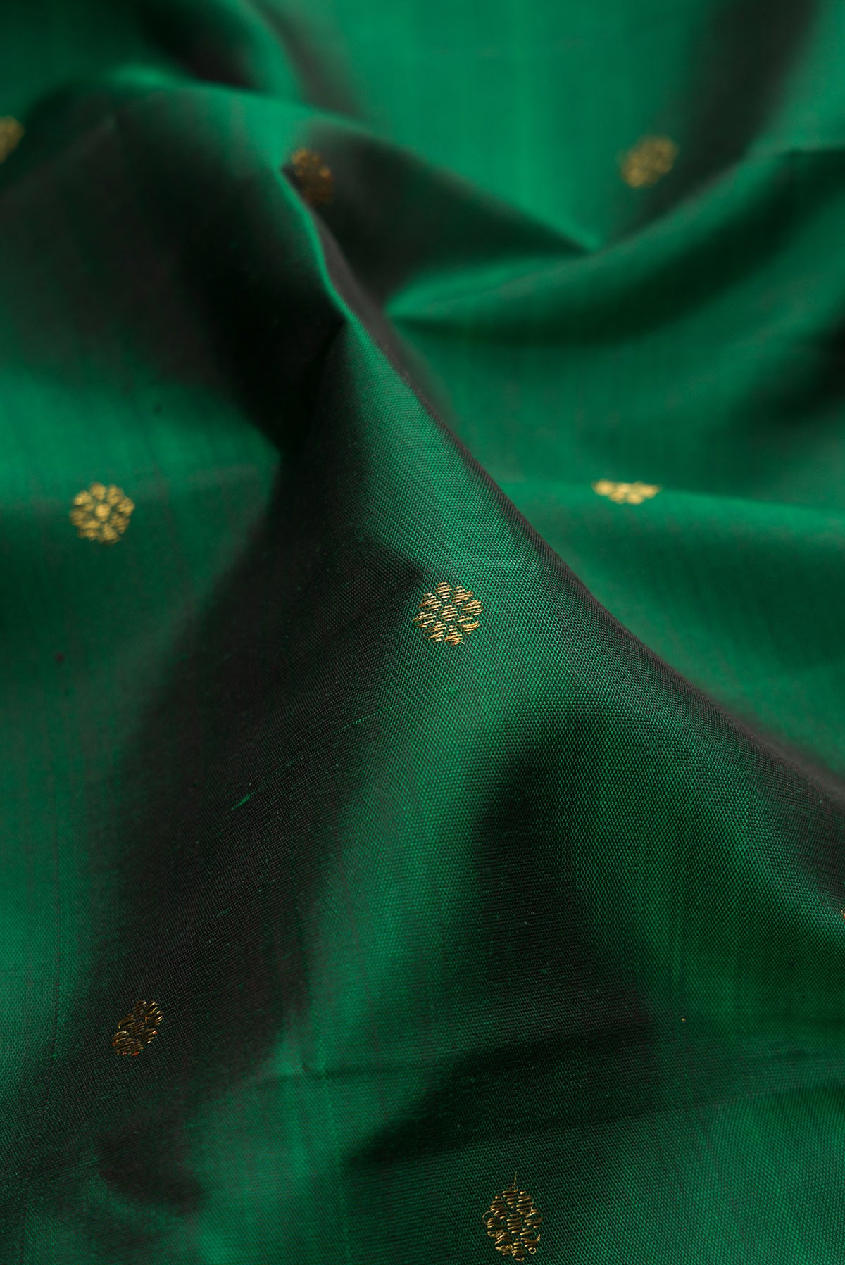 Close up of Pure Silk Pure Zari Green Dual Tone Kanjivaram Saree with Zari Butta on the body and Zari Border.  displaying folds