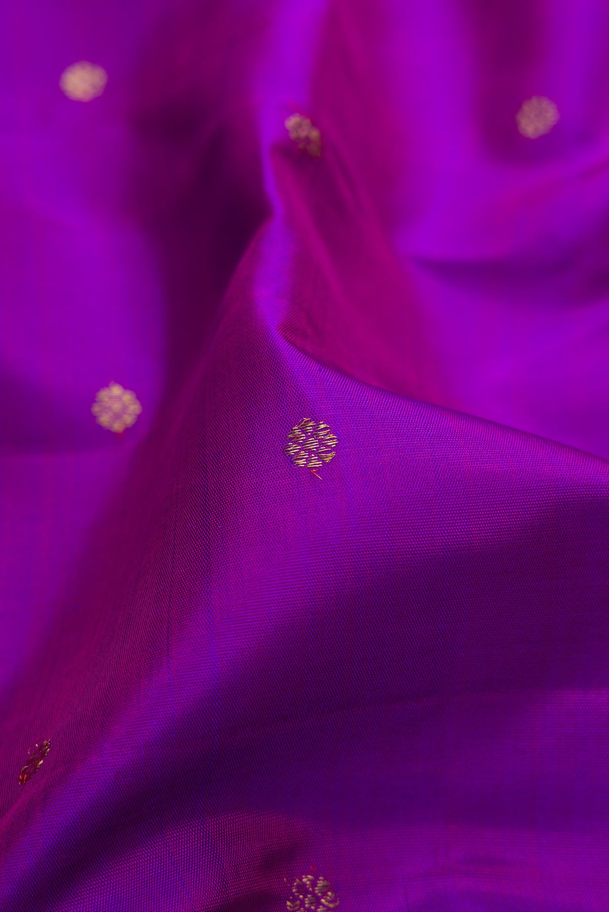 Close up of Pure Silk Pure Zari Purple Dual Tone Kanjivaram Saree with Zari Butta on the body and Zari Border.  displaying folds