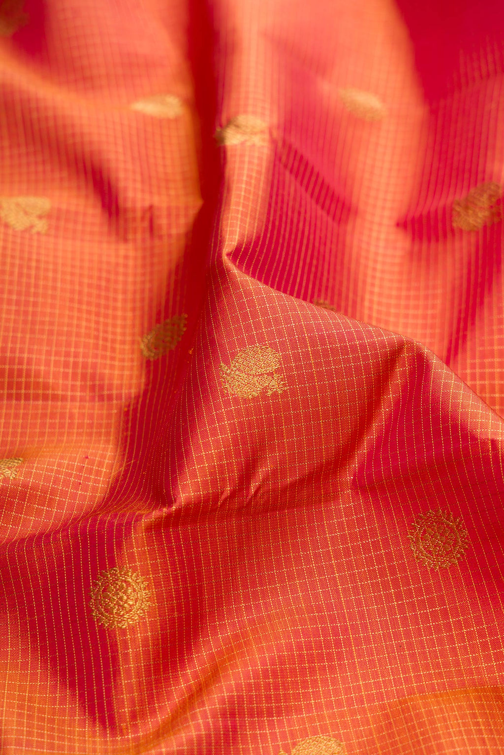 Close up of Pure Silk Pure Zari Pinkish Yellow Dual Tone Kanjivaram Saree with Checked design on the body and Zari Border.  displaying folds