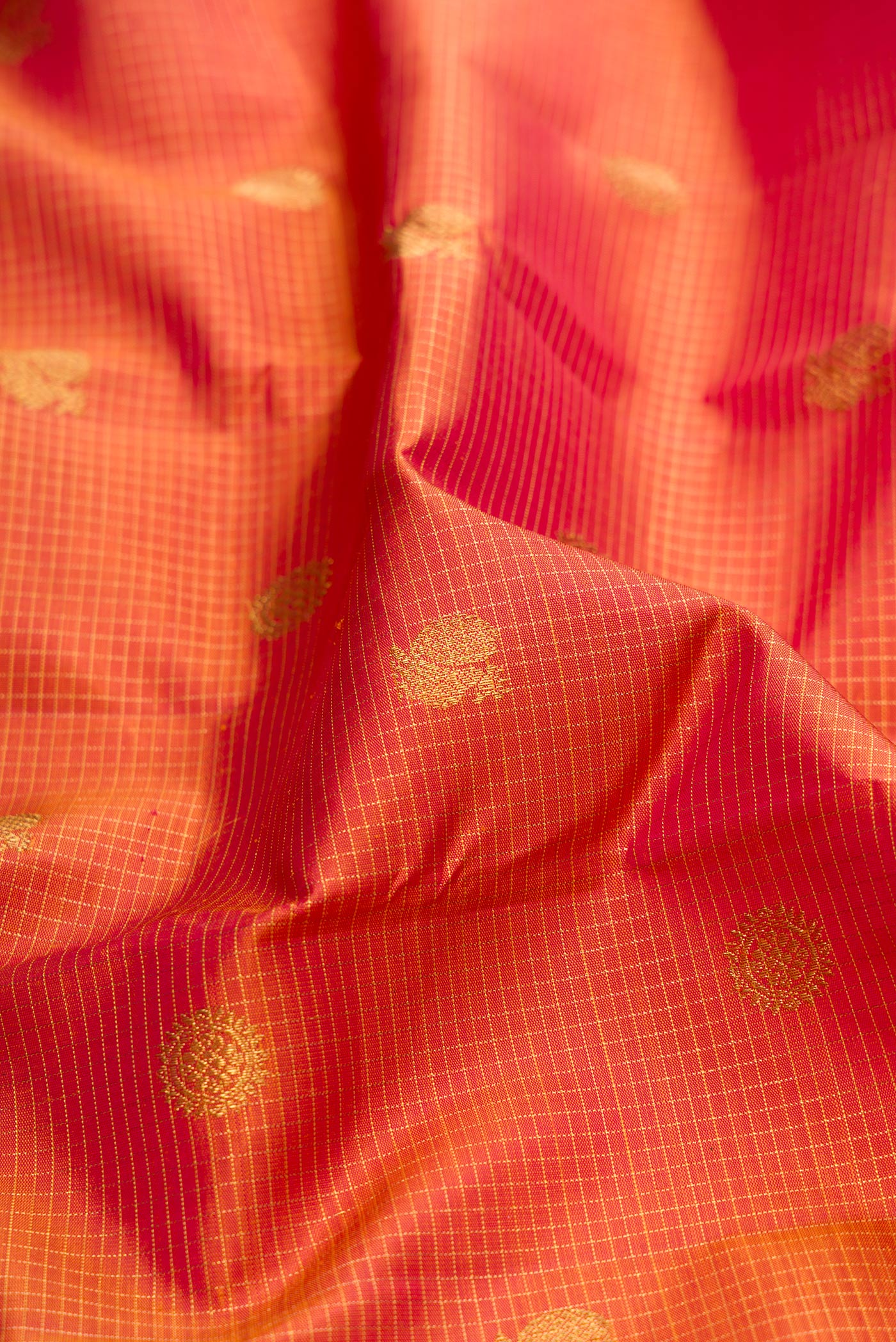 Close up of Pure Silk Pure Zari Pinkish Yellow Dual Tone Kanjivaram Saree with Checked design on the body and Zari Border.  displaying folds