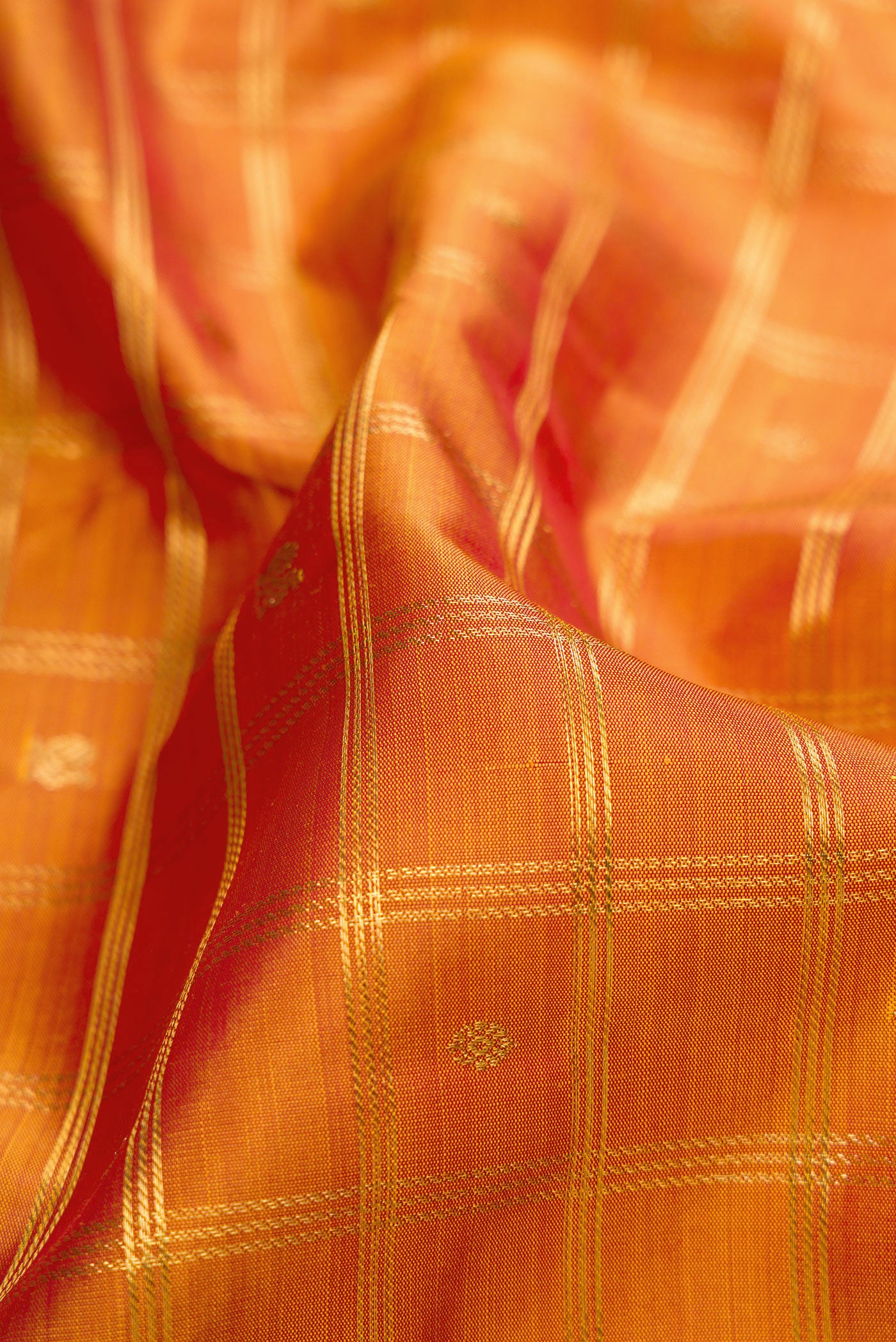 Close up of Pure Silk Pure Zari Mustard Dual Tone Kanjivaram Saree with Checked design on the body and Zari Border.  displaying folds