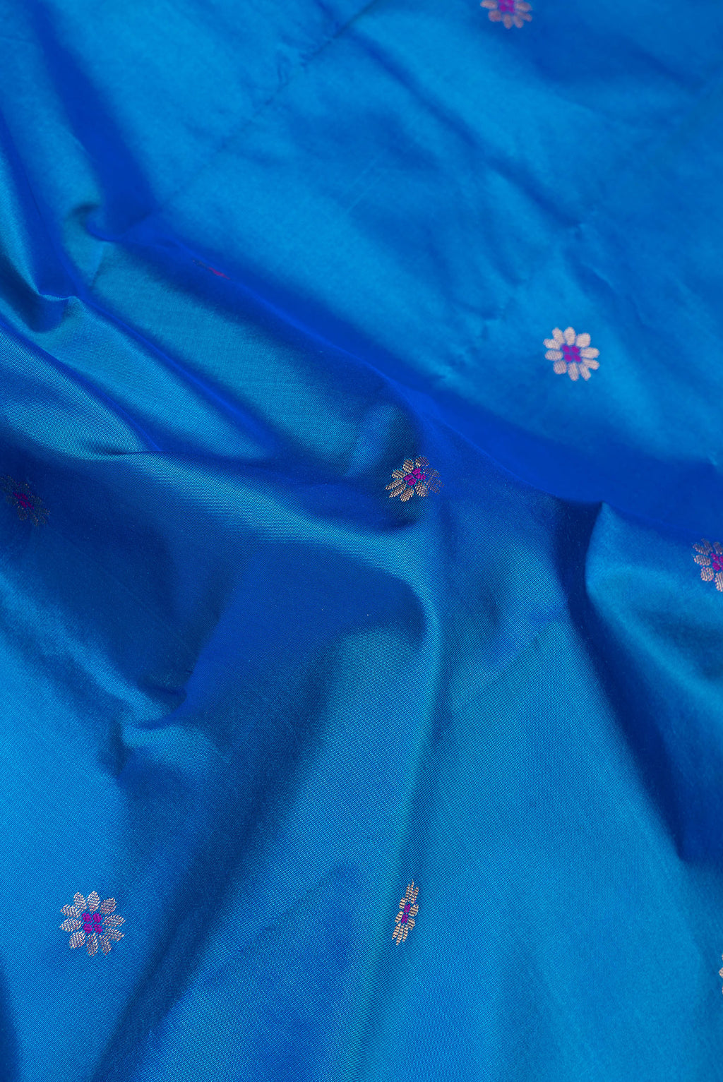 Close up of Peacock Blue Blended Paithani Silk Saree with Zari And Thread Butta on the body and Zari Border.  displaying folds