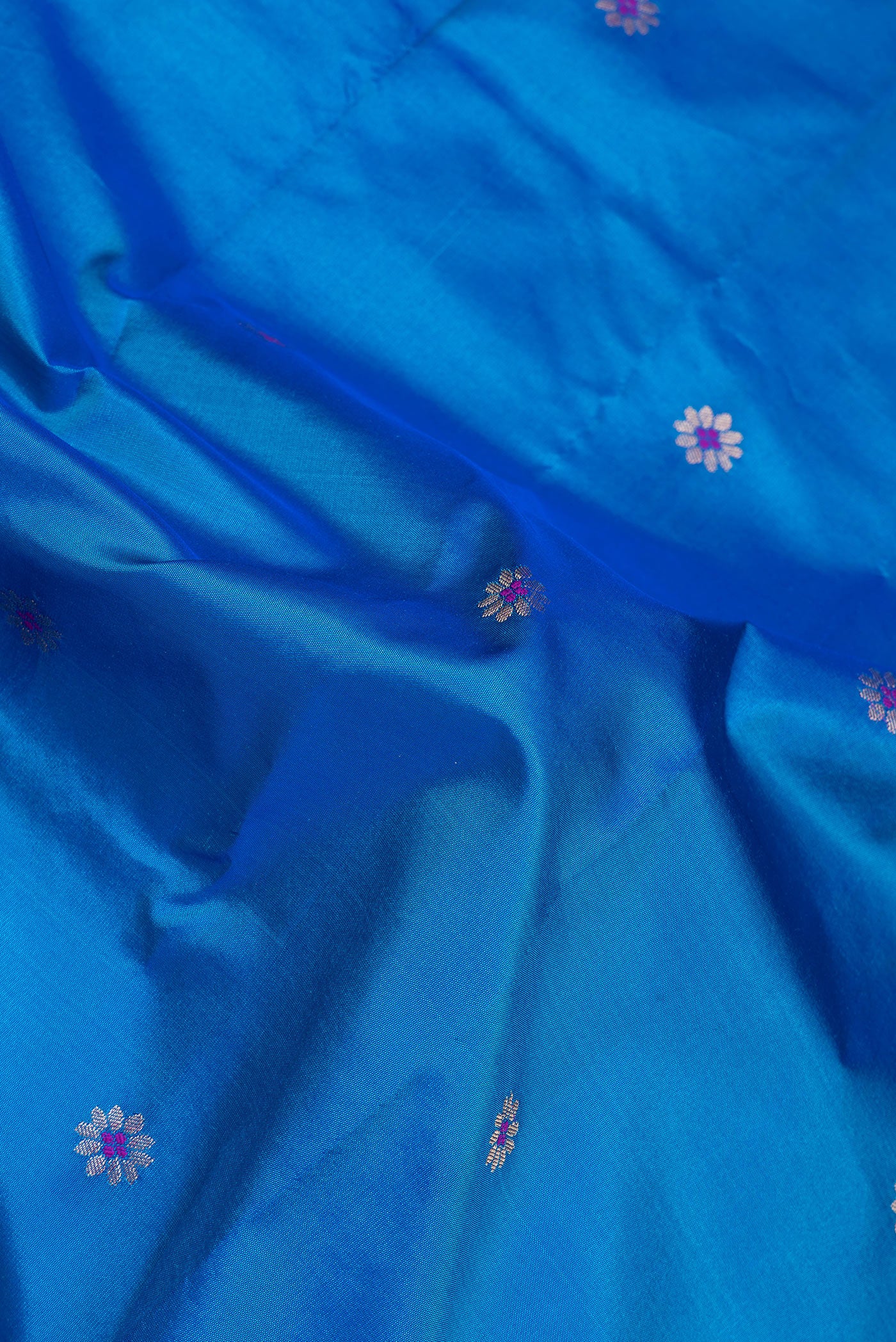 Close up of Peacock Blue Blended Paithani Silk Saree with Zari And Thread Butta on the body and Zari Border.  displaying folds