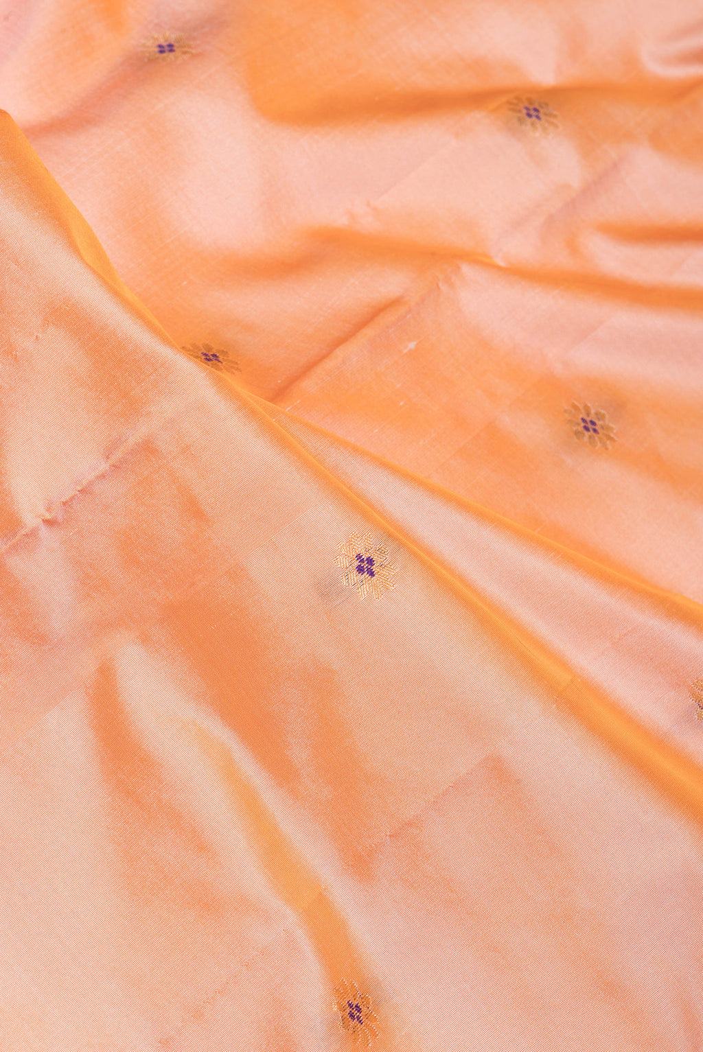 Close up of Peach Dual Tone Blended Paithani Silk Saree with Zari Butta on the body and Zari Border.  displaying folds
