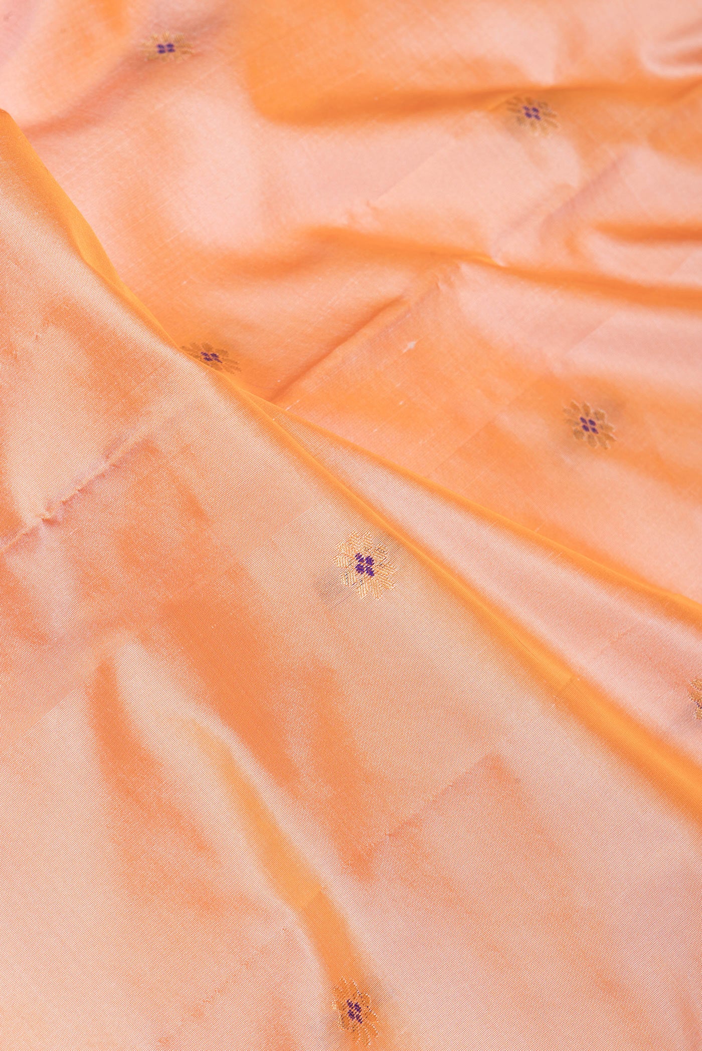 Close up of Peach Dual Tone Blended Paithani Silk Saree with Zari Butta on the body and Zari Border.  displaying folds