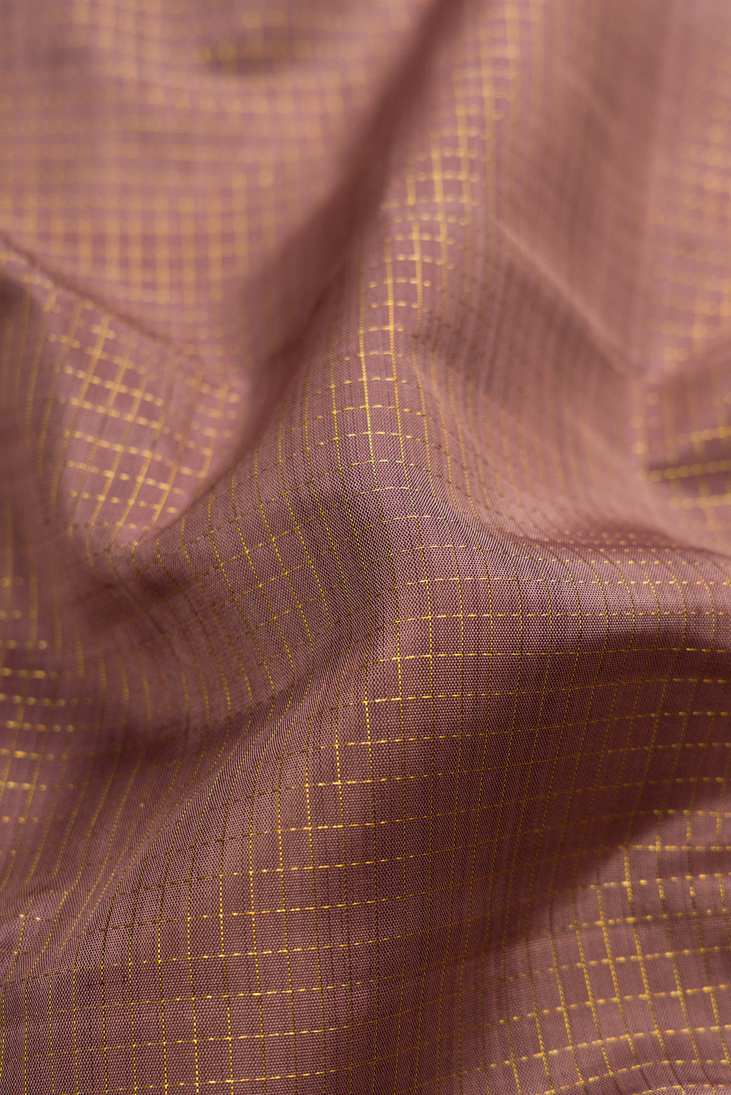 Close up of Brown Dual Tone Kanjivaram Silk Saree with Checked design on the body and Zari Border.  displaying folds