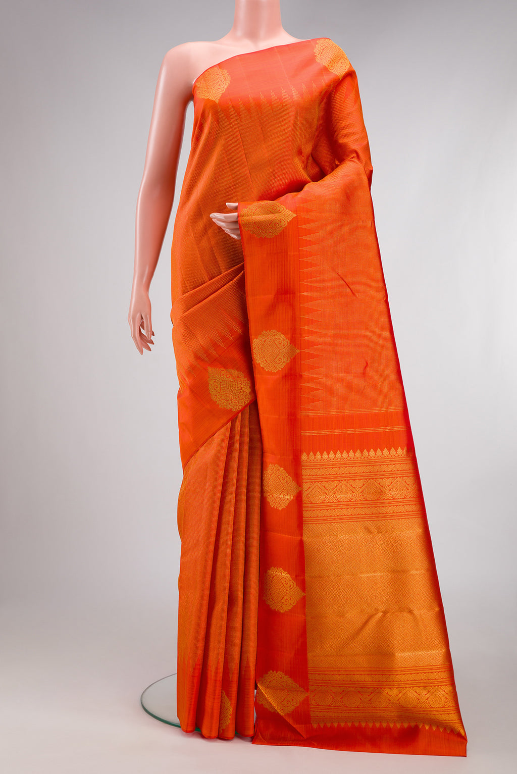 Orange Kanjivaram Silk Saree with Stripes on the body and Fancy Border.  displayed on a mannequin