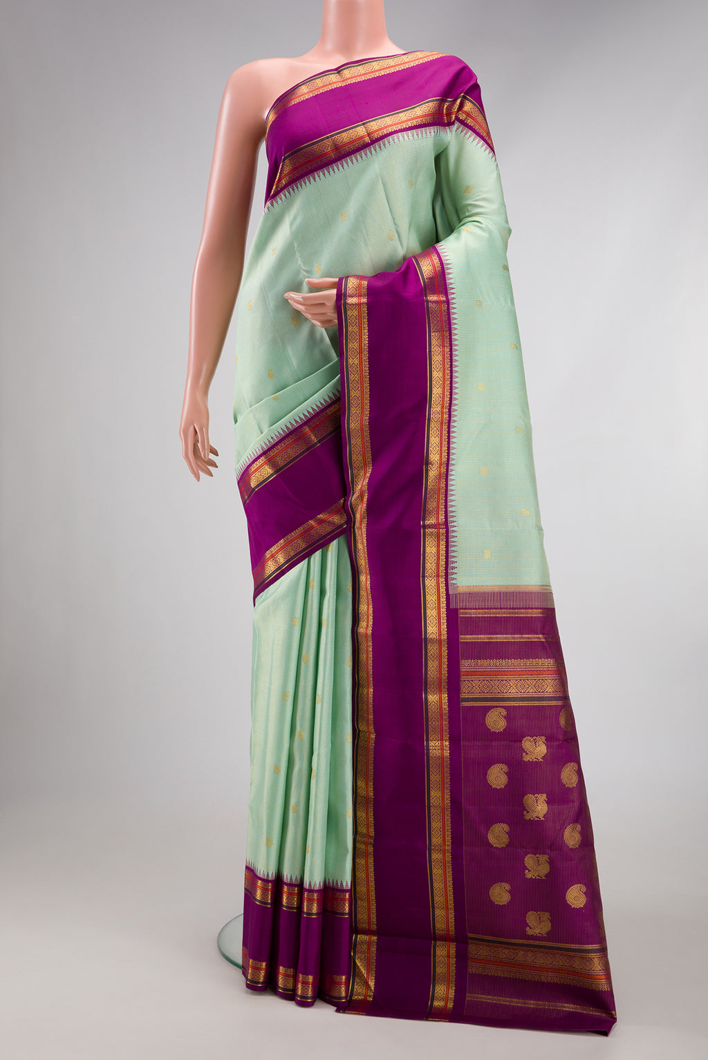 Mint Green Kanchipuram Silk Saree with Checked design on the body and Zari Border.  displayed on a mannequin