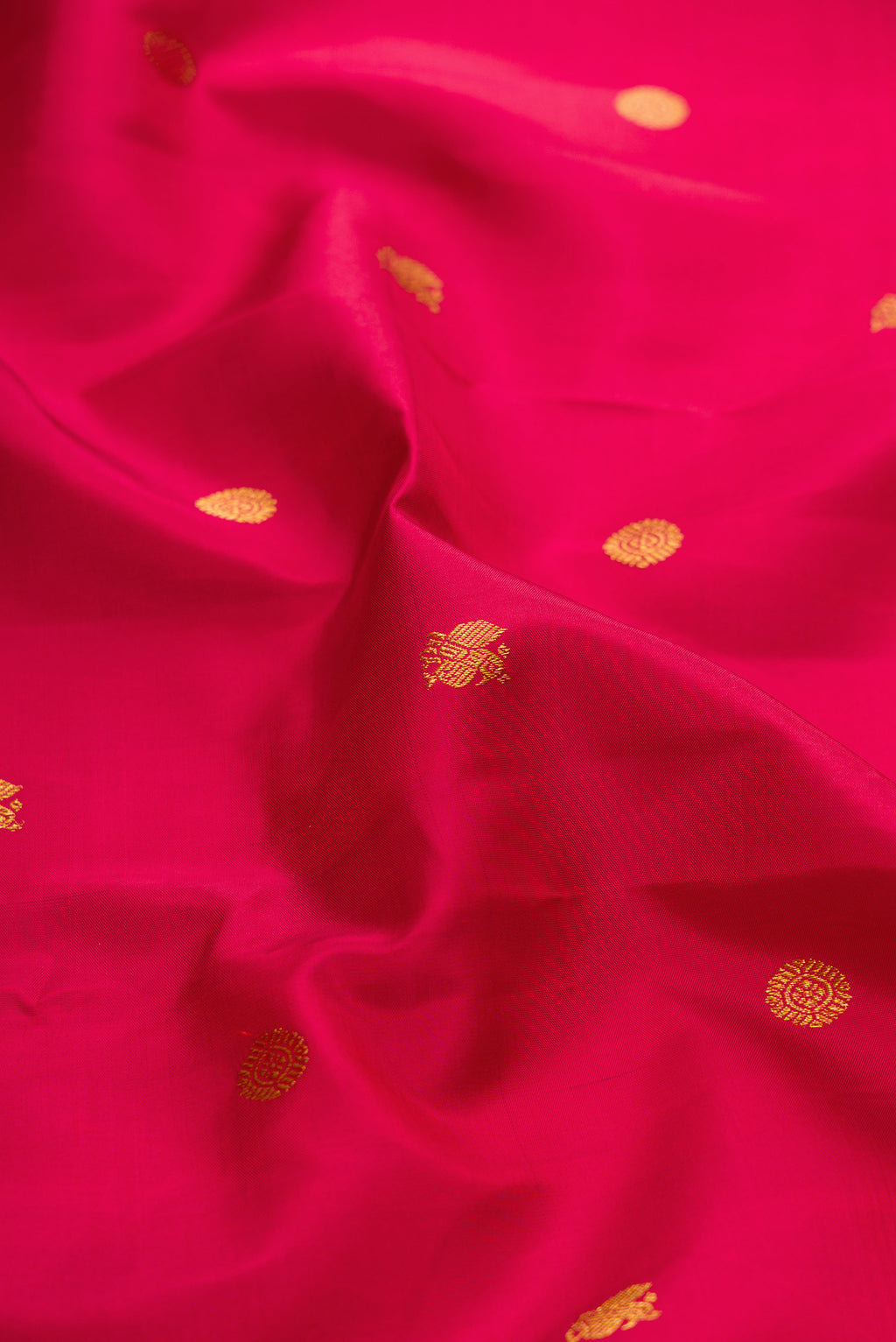 Close up of Red Kanchipuram Silk Saree with Zari Butta on the body and Zari Border.  displaying folds