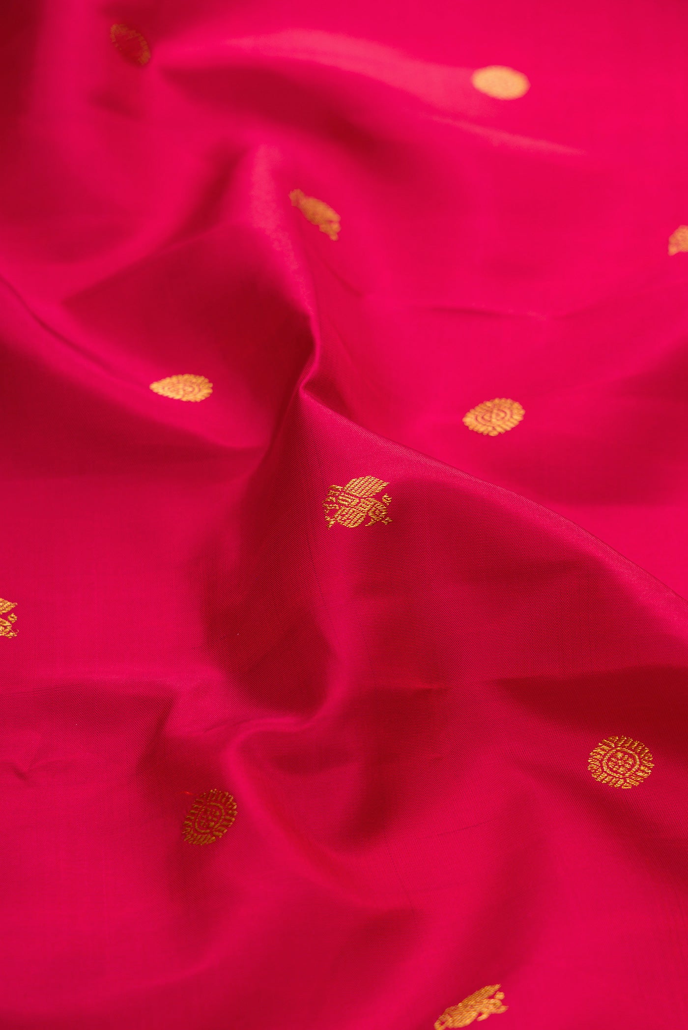 Close up of Red Kanchipuram Silk Saree with Zari Butta on the body and Zari Border.  displaying folds