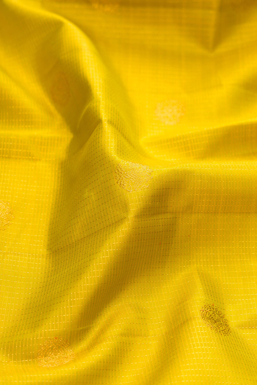 Close up of Parrot Green Kanchipuram Silk Saree with Zari Butta on the body and Zari Border.  displaying folds