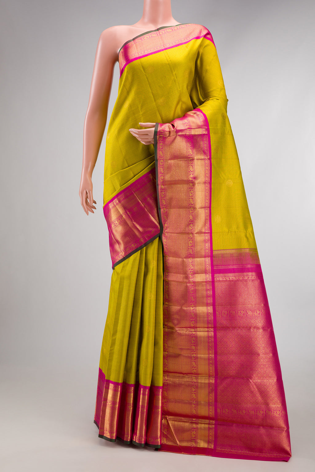 Parrot Green Kanchipuram Silk Saree with Zari Butta on the body and Zari Border.  displayed on a mannequin