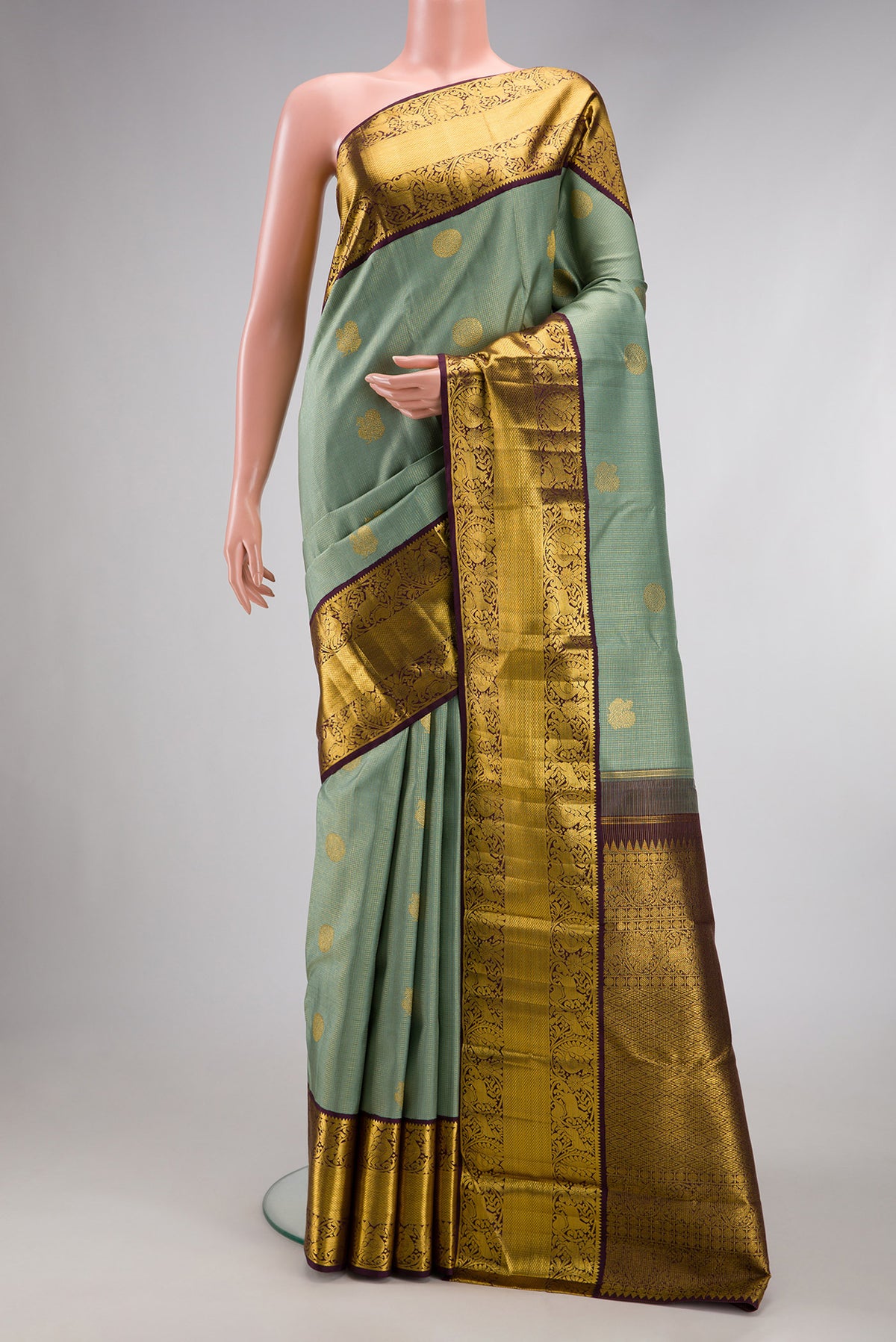Green Dual Tone Kanchipuram Silk Saree with Checked design on the body and Fancy Border.  displayed on a mannequin