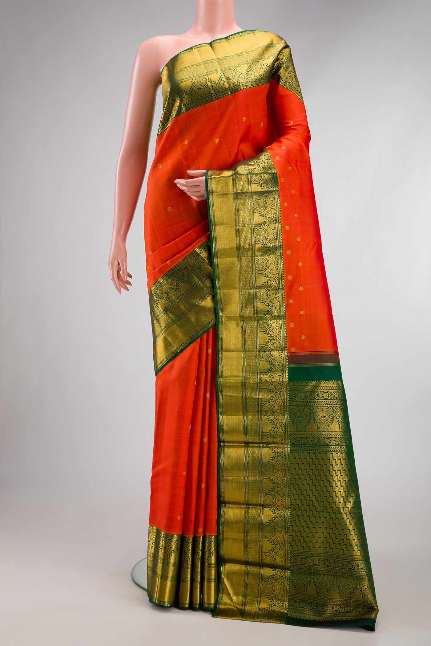 Orange Kanchipuram Silk Saree with Zari Butta on the body and Zari Border.  displayed on a mannequin