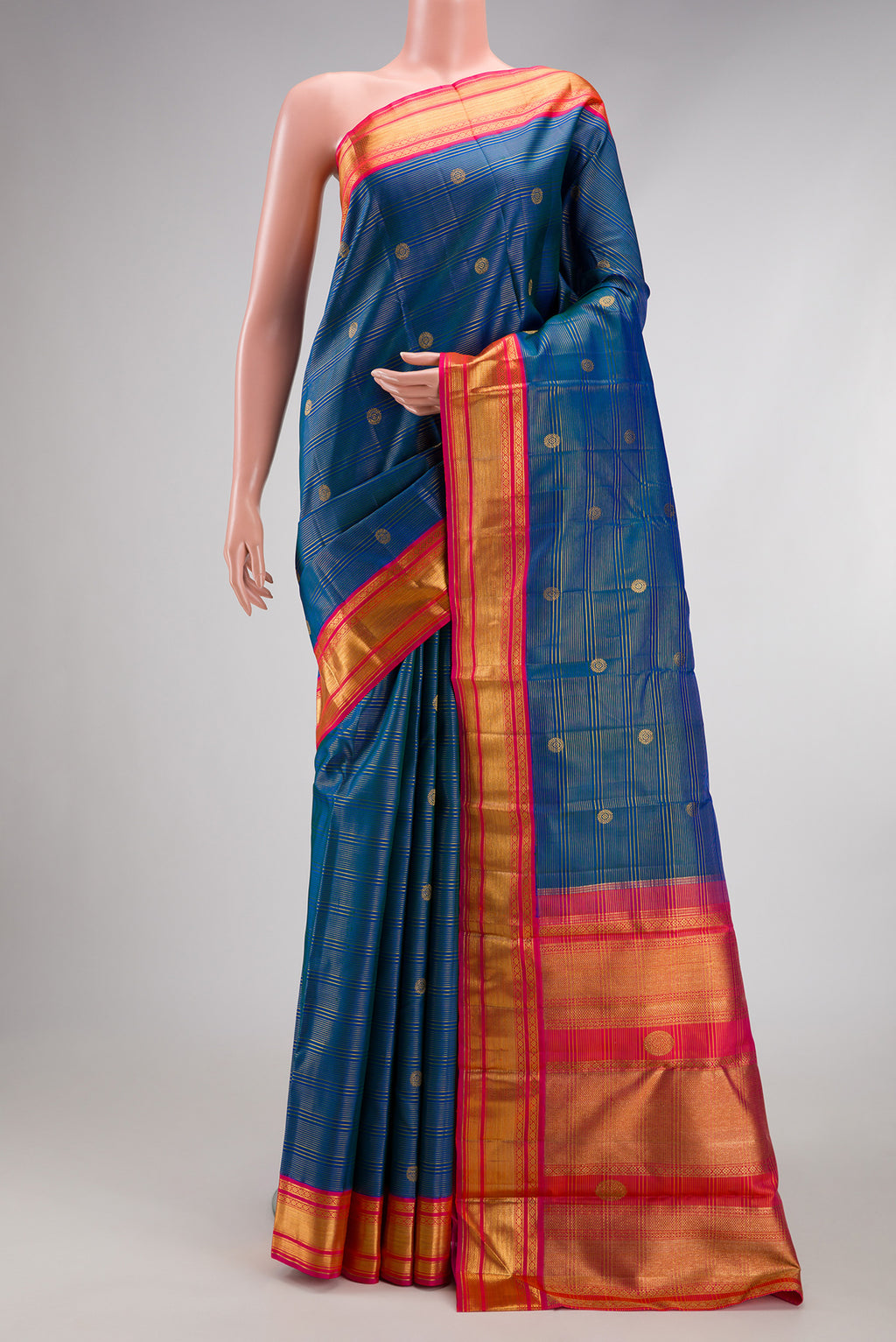 Peacock Blue Kanchipuram Silk Saree with Zari Butta on the body and Zari Border.  displayed on a mannequin