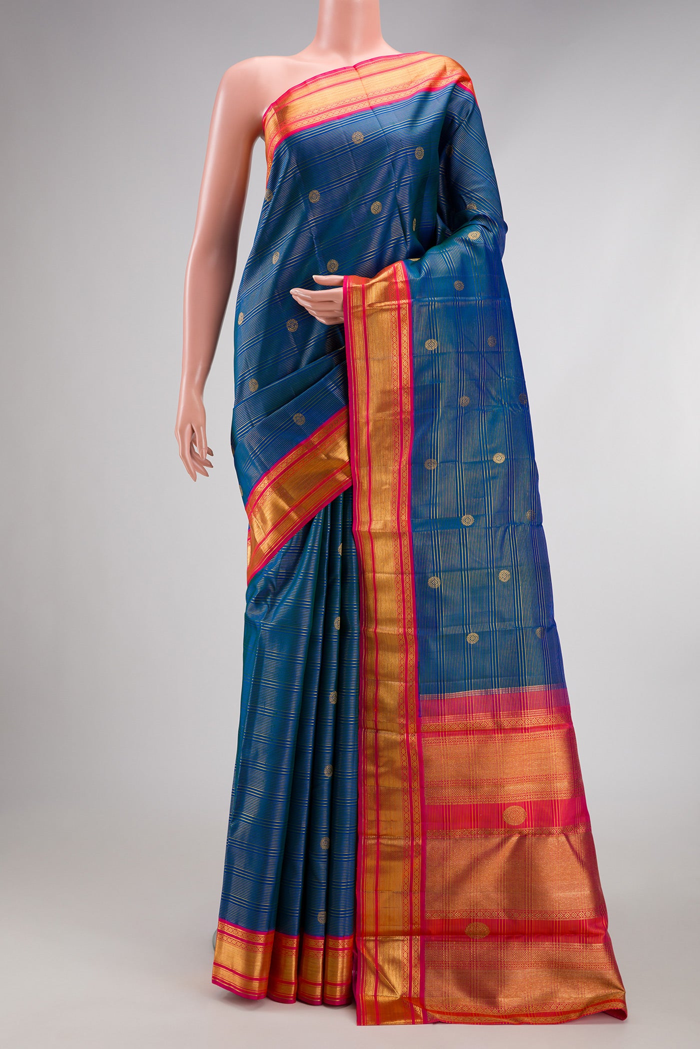Peacock Blue Kanchipuram Silk Saree with Zari Butta on the body and Zari Border.  displayed on a mannequin