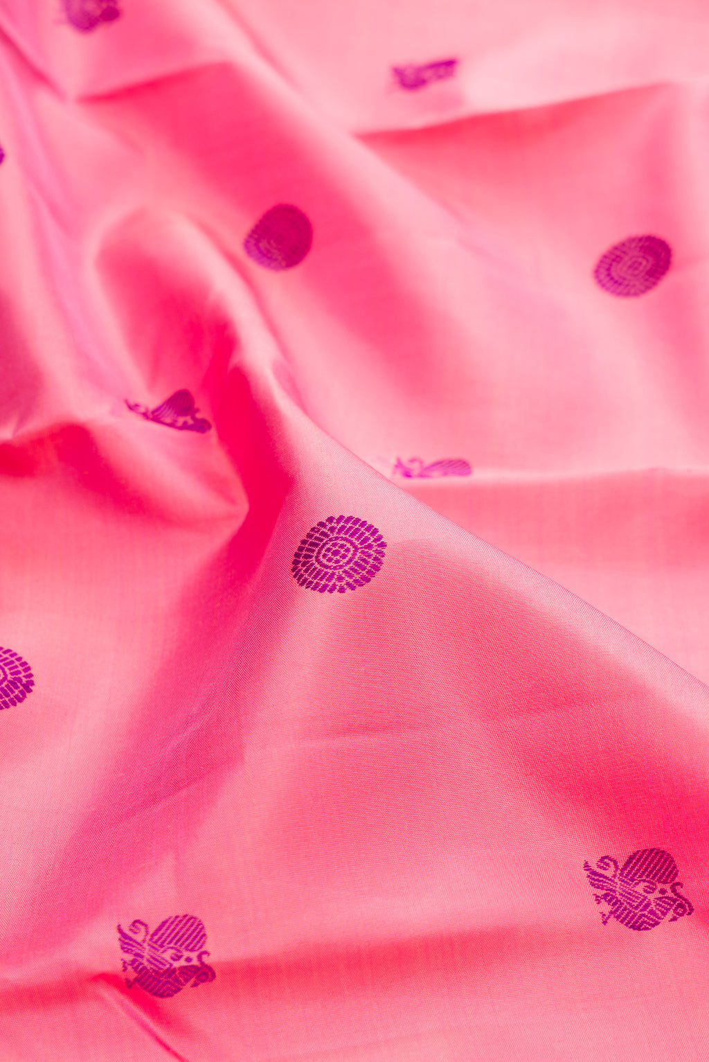 Close up of Pure Silk Pure Zari Pink Kanchipuram Saree with Thread Butta on the body and Zari Border.  displaying folds