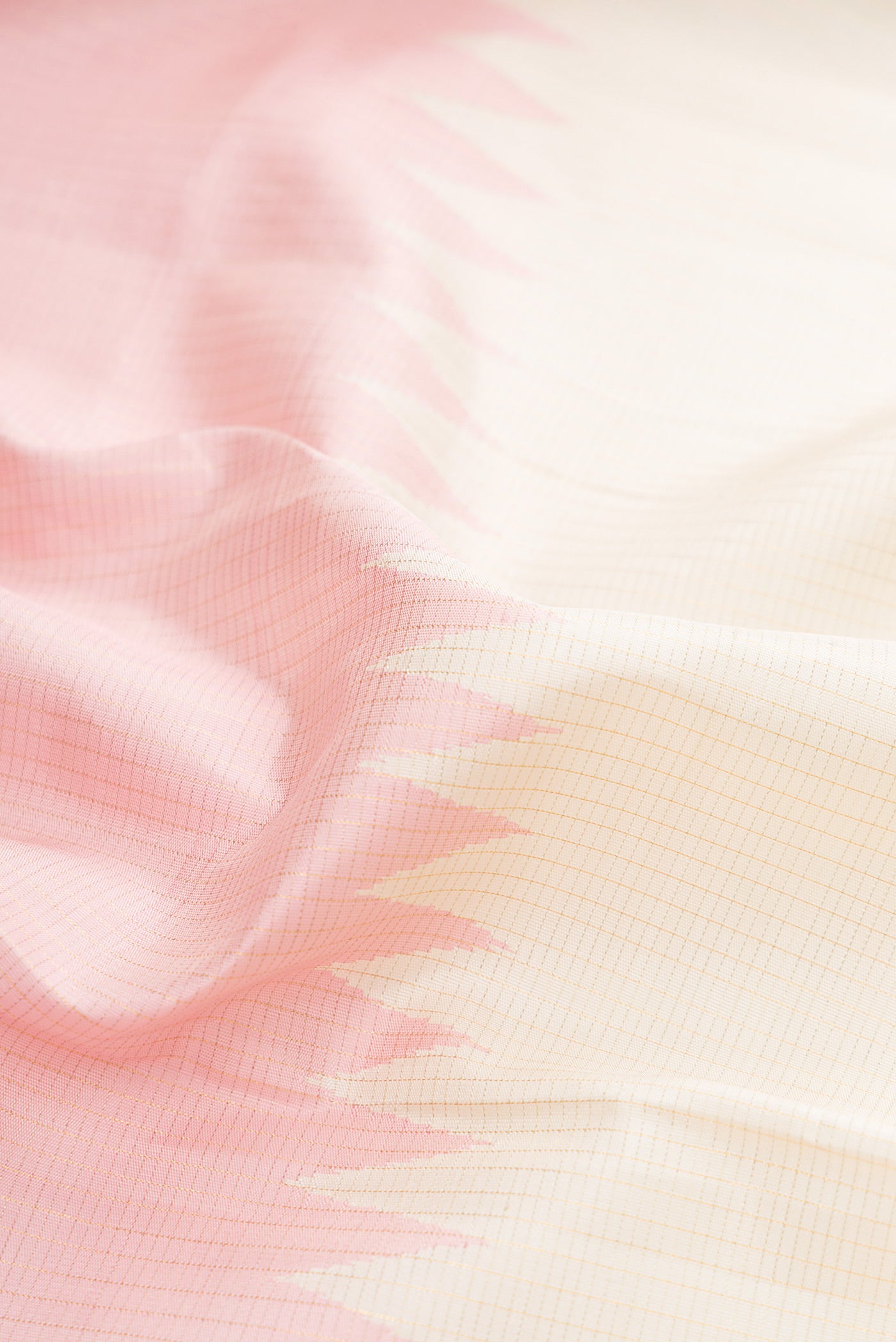 Close up of Off White Kanchipuram Silk Saree with Checked design on the body and Rising Temple Border.  displaying folds