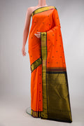 Orange Kanjivaram Silk Saree with Thread Butta on the body and Zari Border.  displayed on a mannequin
