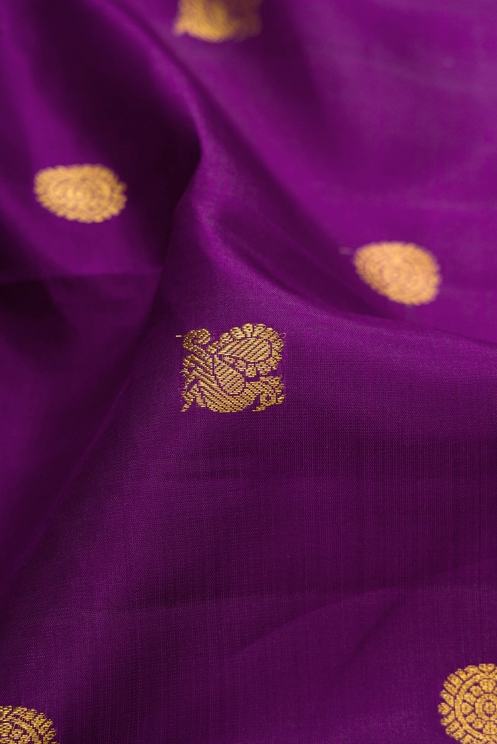 Close up of Purple Kanjivaram Silk Saree with Zari Butta on the body and Zari Border.  displaying folds