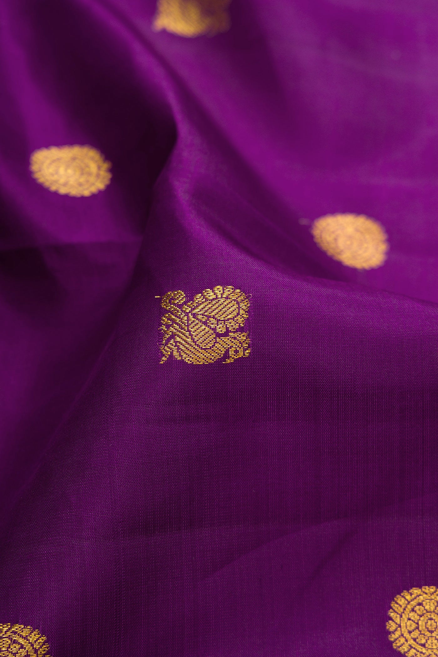 Close up of Purple Kanjivaram Silk Saree with Zari Butta on the body and Zari Border.  displaying folds
