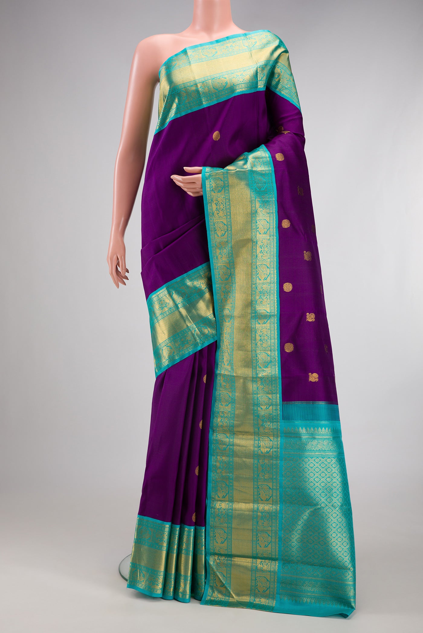 Purple Kanjivaram Silk Saree with Zari Butta on the body and Zari Border.  displayed on a mannequin