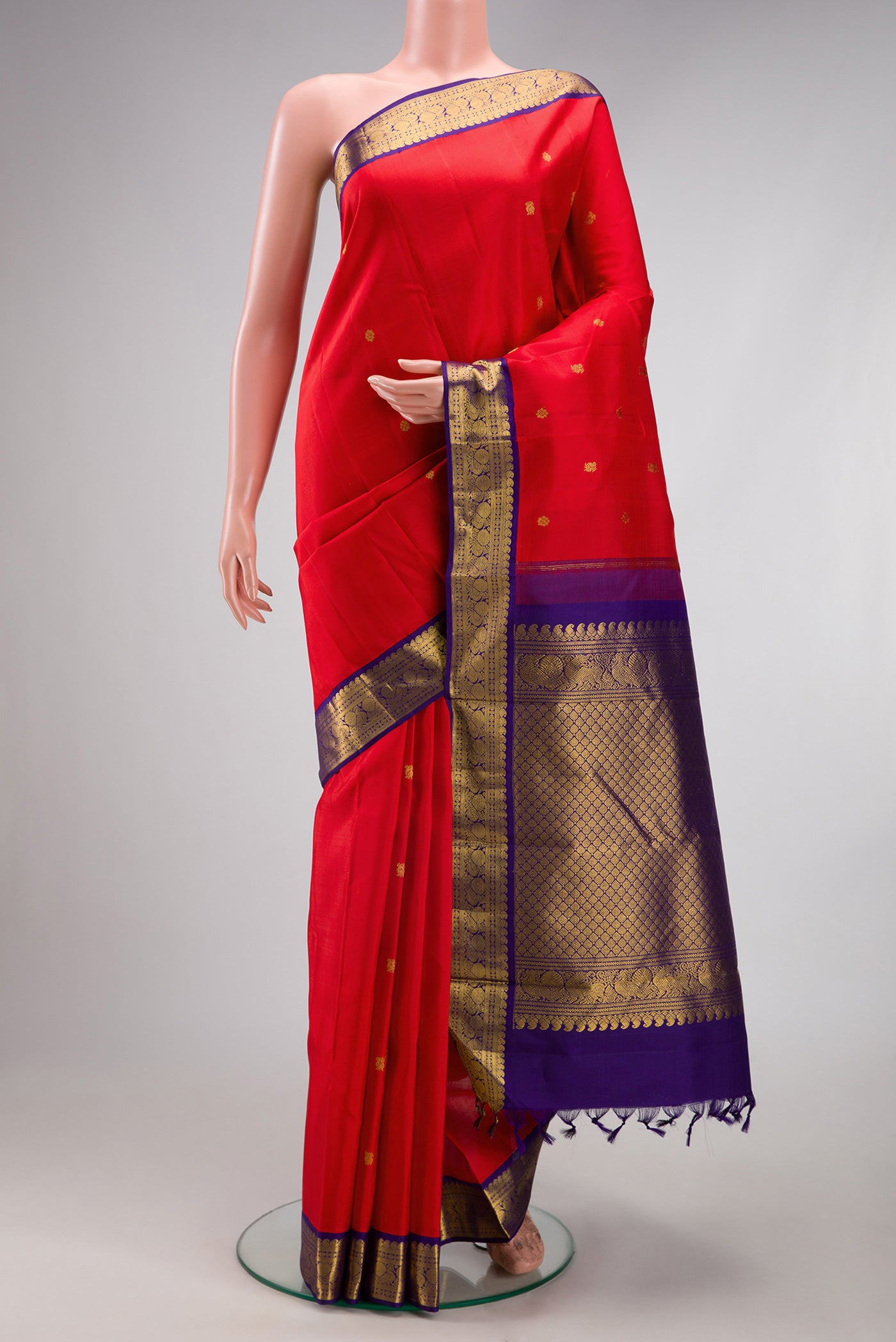 Red Kanjivaram Silk Saree with Zari Butta on the body and Zari Border.  displayed on a mannequin