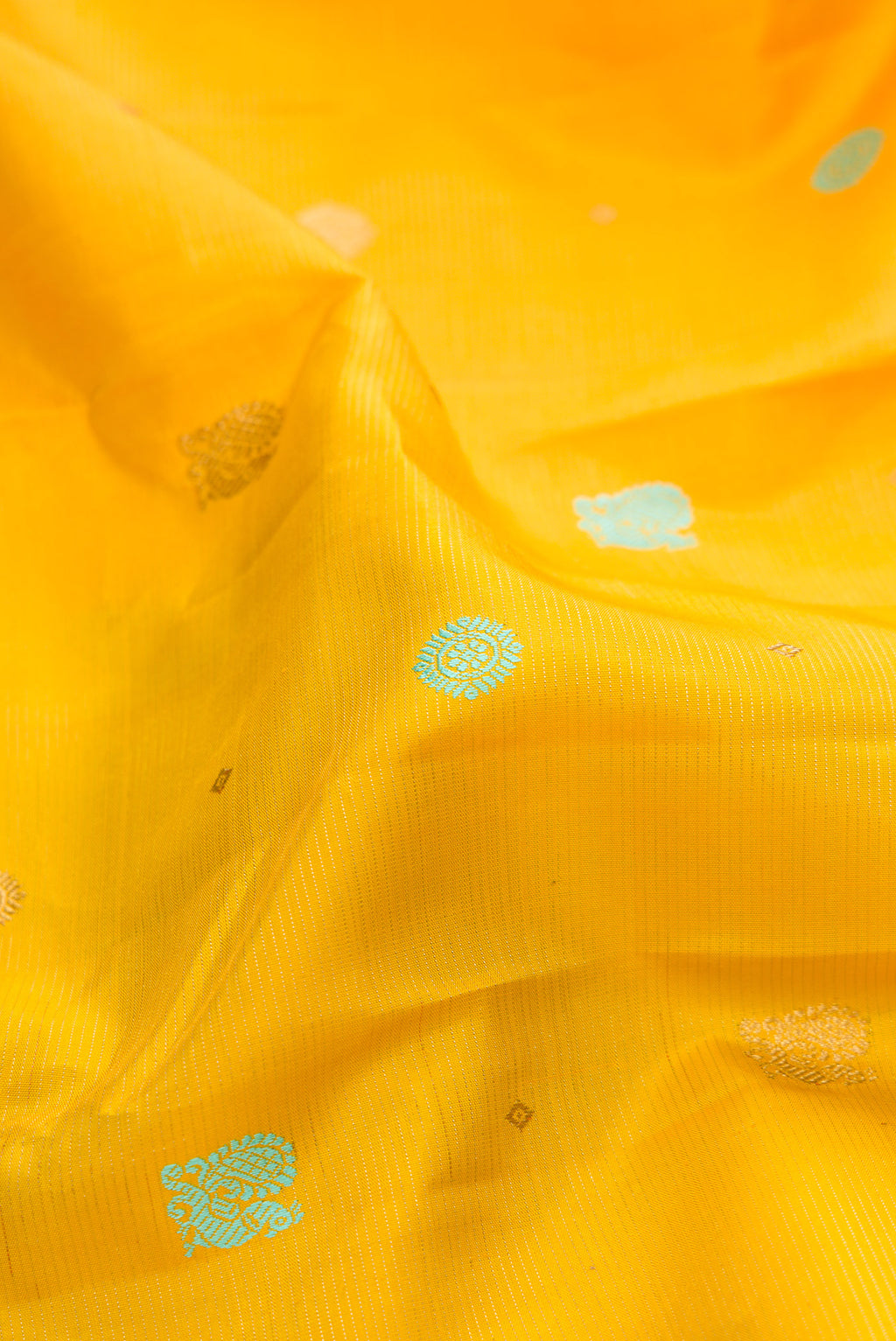 Close up of Pure Silk Pure Zari Yellow Kanchipuram Saree with Thread Butta on the body and Zari Border.  displaying folds