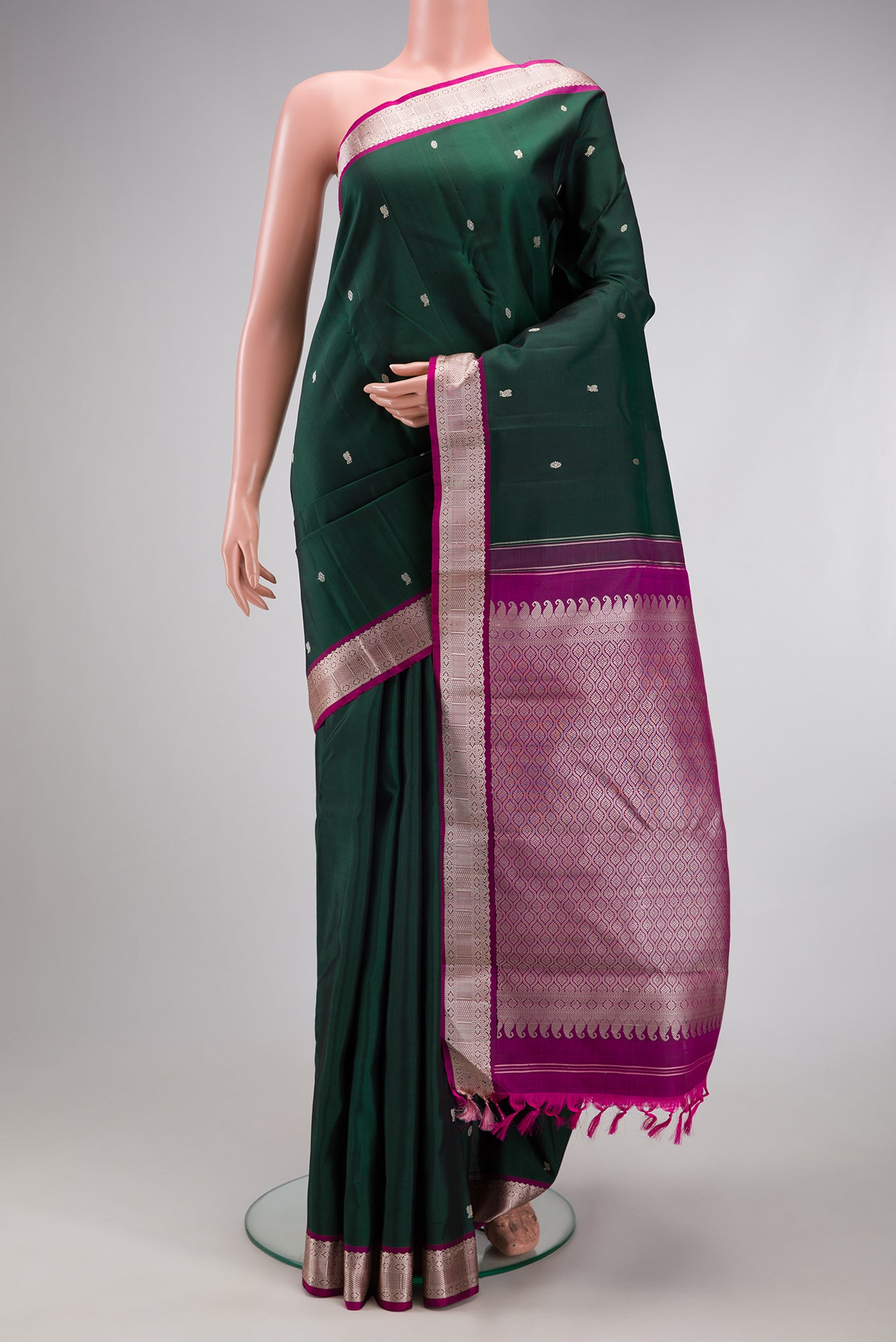 Bottle Green Kanchipuram Silk Saree with Thread Butta on the body and Thread Border.  displayed on a mannequin