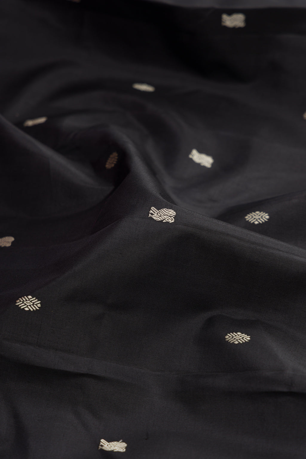 Close up of Black Kanchipuram Silk Saree with Thread Butta on the body and Thread Border.  displaying folds
