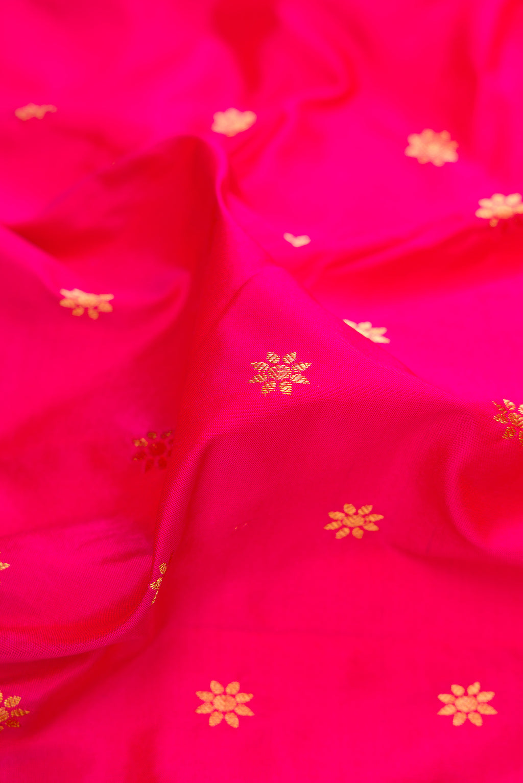 Close up of Dark Pink Paithani Silk Saree with Zari Butta on the body and Zari Border.  displaying folds