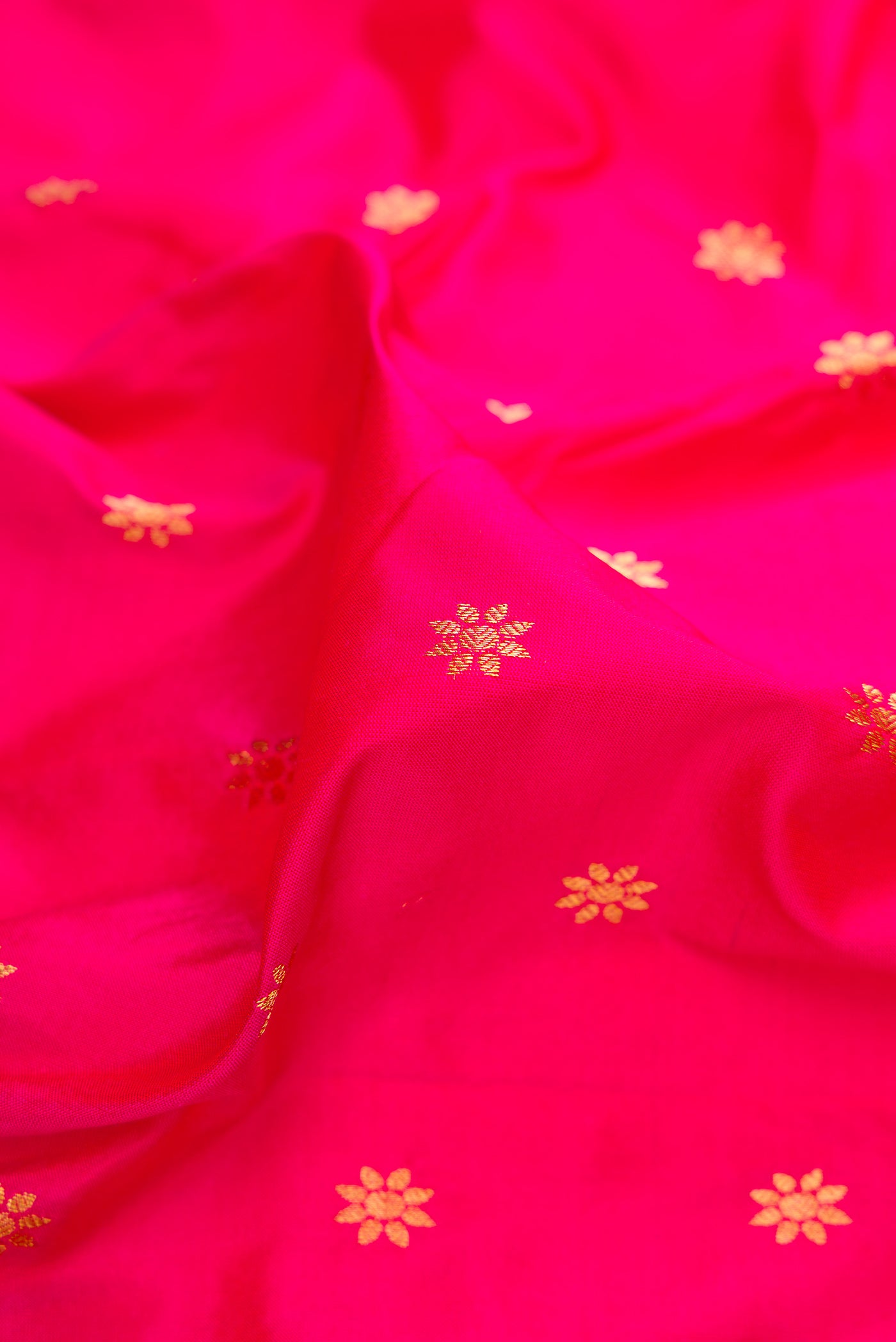 Close up of Dark Pink Paithani Silk Saree with Zari Butta on the body and Zari Border.  displaying folds