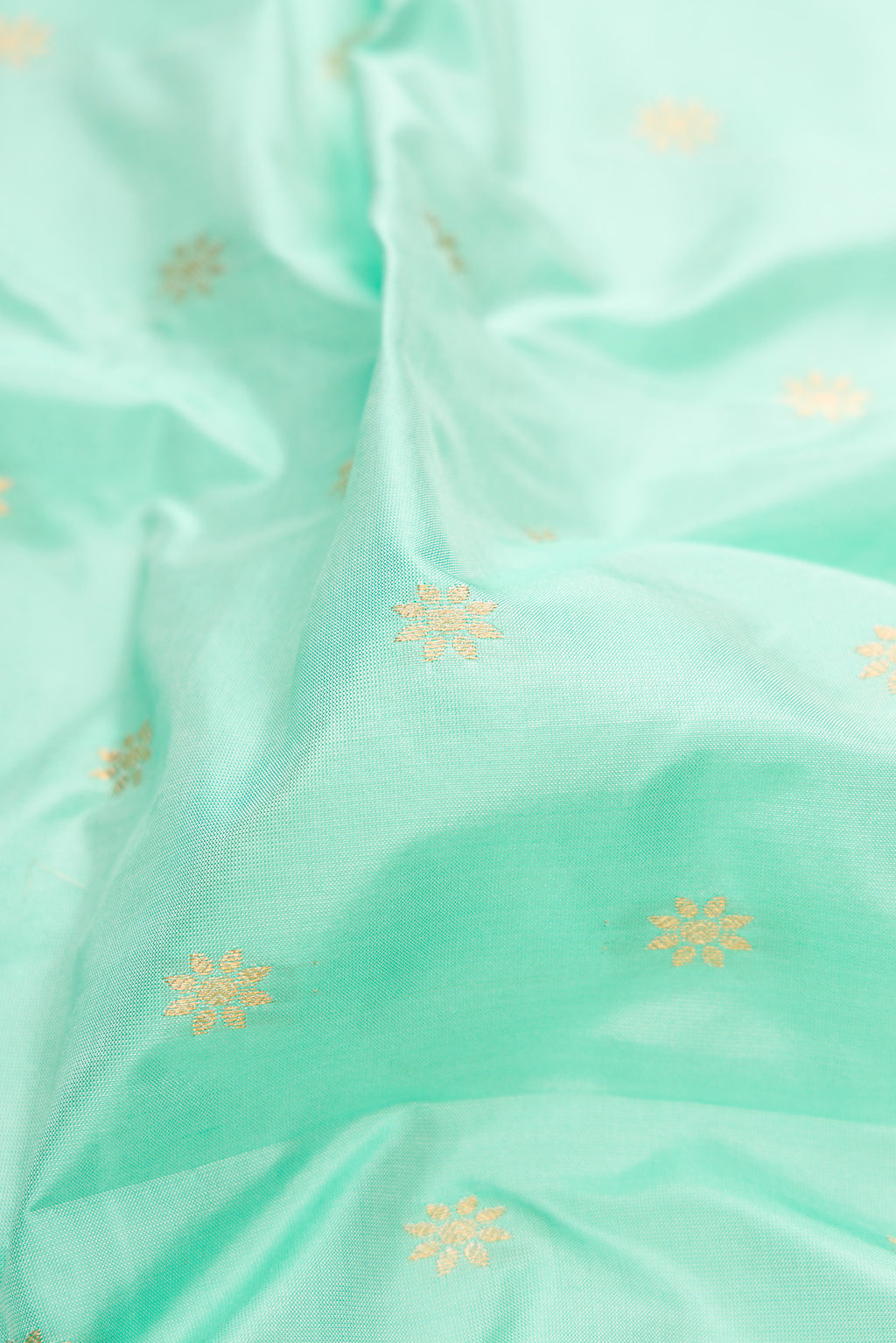 Close up of Light Blue Paithani Silk Saree with Zari Butta on the body and Zari Border.  displaying folds
