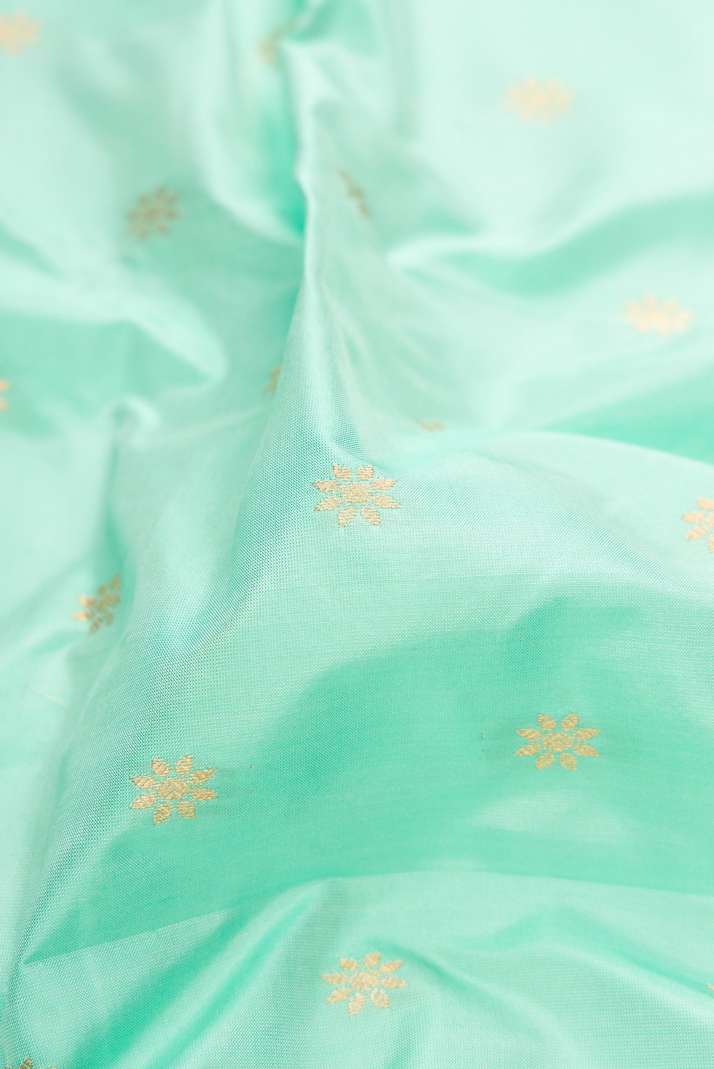 Close up of Light Blue Paithani Silk Saree with Zari Butta on the body and Zari Border.  displaying folds