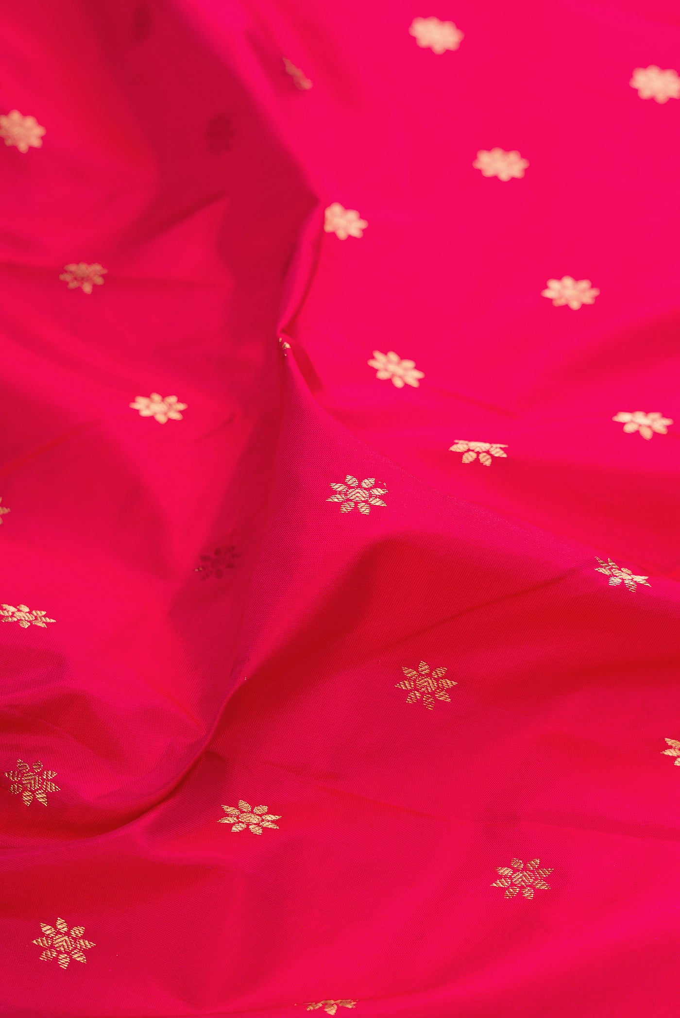 Close up of Dark Pink Paithani Silk Saree with Zari Butta on the body and Zari Border.  displaying folds